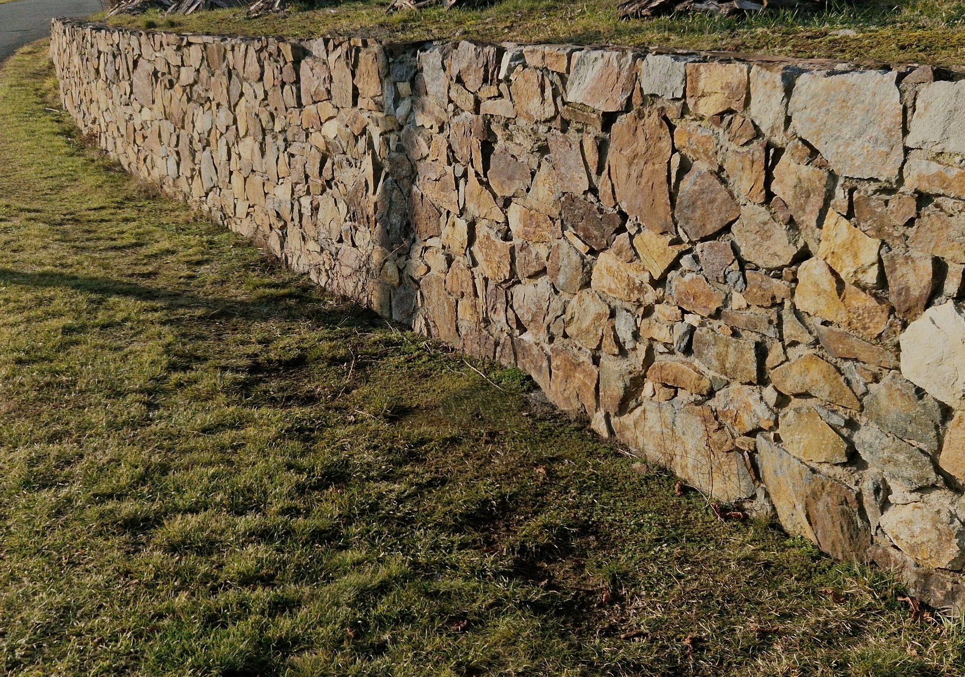 Natural rock stone retaining wall construction in garden landscape